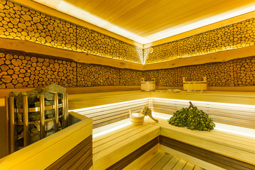 Un sauna en bois éclairé par des projecteurs dissimulés