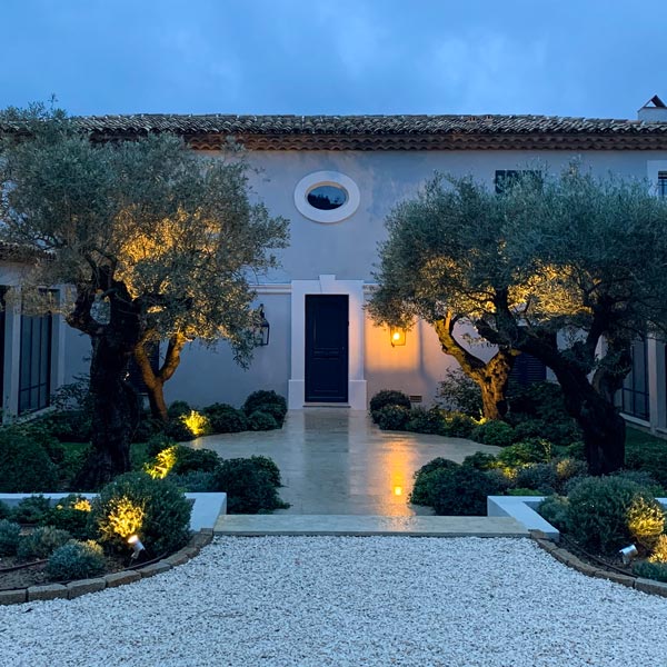 Une entrée de maison aménagée avec les projecteurs sur lyre de la Maison ORSTEEL