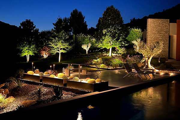 Terrasse et piscine mises en lumière par nos projecteurs borne et nos spots encastrés.
