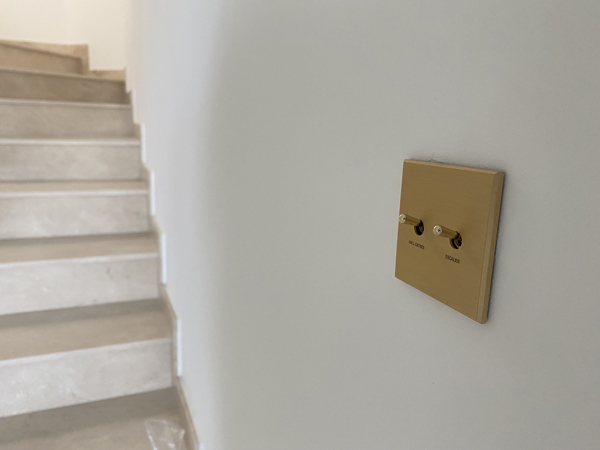 Interrupteur en laiton doré avec gravure installé dans la villa SJ