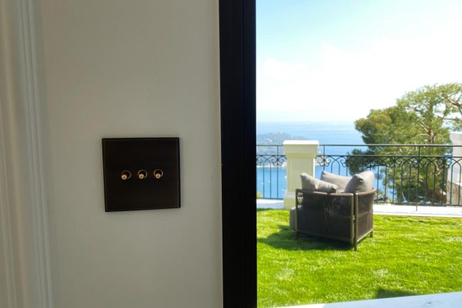 Un interrupteur noir mat dans la salon de la villa Ama avec vue sur la mer